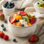 Cottage cheese fruit salad in bowl with fresh berries and tropical fruit — healthy breakfast or snack