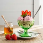 Cottage cheese ice cream dessert in green glass bowl topped with fresh strawberries and mint, printable recipe card