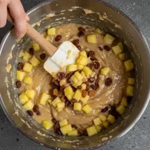 Folding raisins and fruit into bread pudding mix