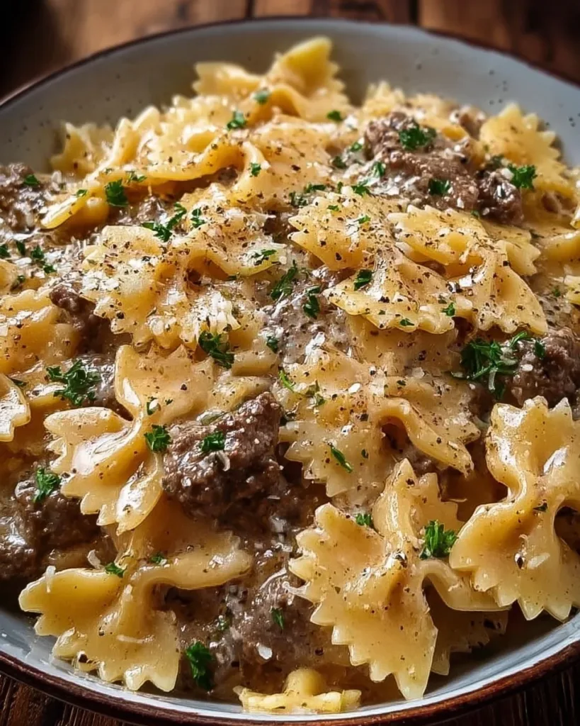 Creamy Parmesan garlic beef bowtie pasta dish served with herbs