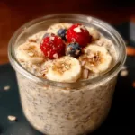 Bowl of colorful overnight oats topped with fresh fruits and nuts